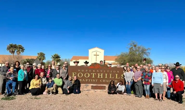 Some of the members of Superstition Foothills Baptist Church in Gold Canyon taking a picture out in front of the church sign.